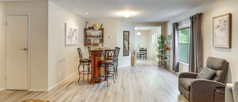 A spacious living area with a dining table, chairs, a sofa, and a bench.