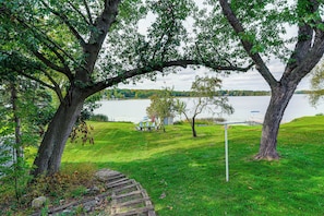 Uma área gramada com árvores e um lago.