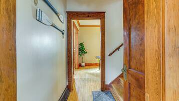 A wooden hallway with a door, a plant, and a small table.