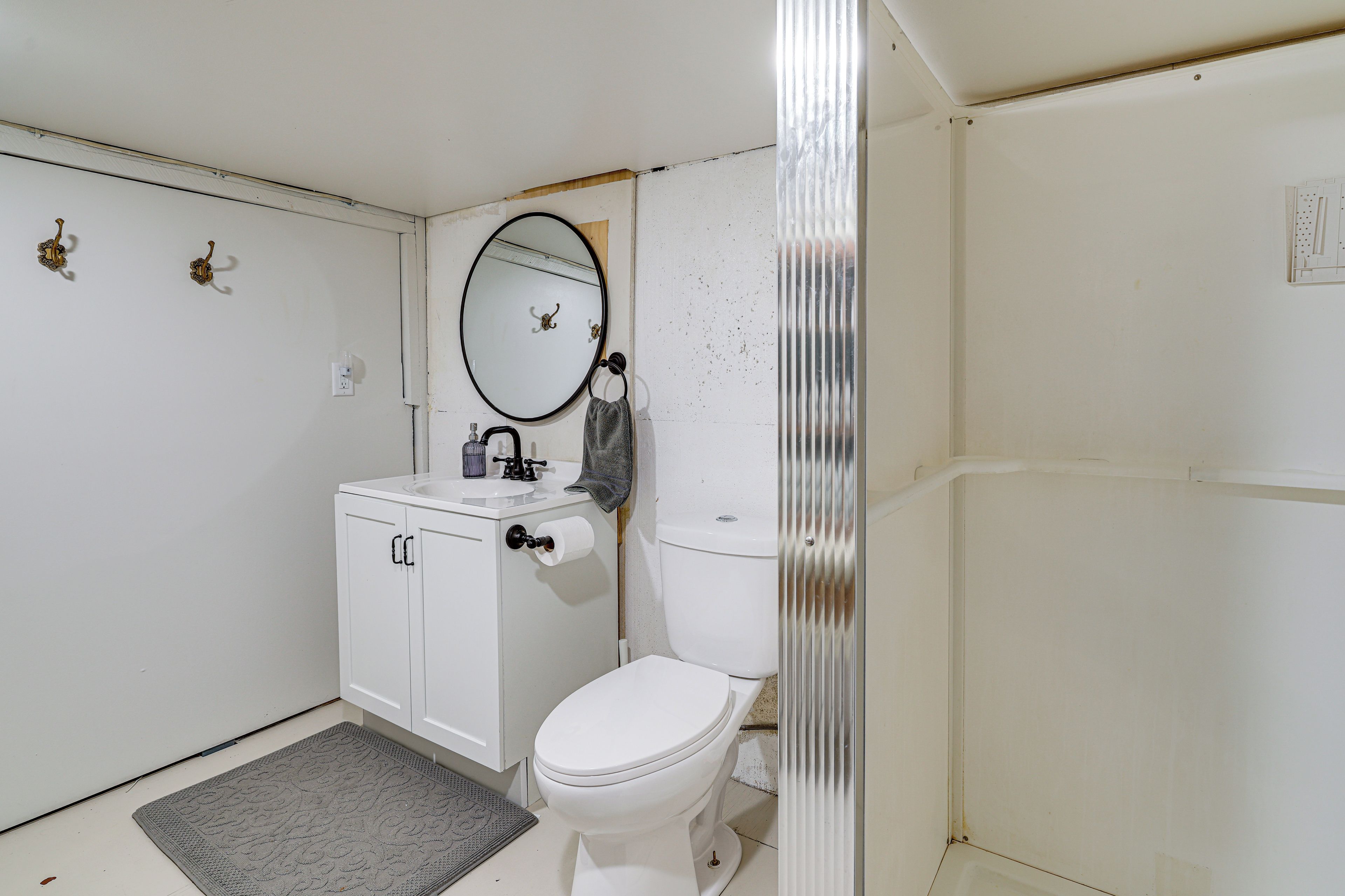 Pieni, käytännöllinen kylpyhuone, jossa on wc, pesuallas ja peili.