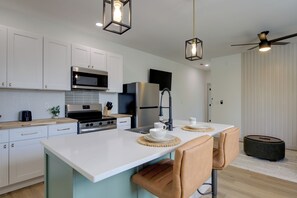 A modern kitchen with white cabinetry, stainless steel appliances, and a central island with seating. - Knoxville Extended Base! 3 Mi to Med Center (Knoxville)