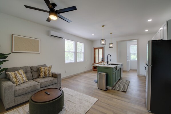 A modern living room with a sofa, a coffee table, and a ceiling fan. - Knoxville Extended Base! 3 Mi to Med Center (Knoxville)
