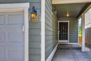 A house entrance with a garage door, a front door, and two wall-mounted lights. - 10 Min to Fairgrounds! Family Retreat in Puyallup (Puyallup)