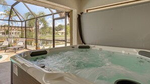 Un jacuzzi con vistas a palmeras y a una zona de piscina.