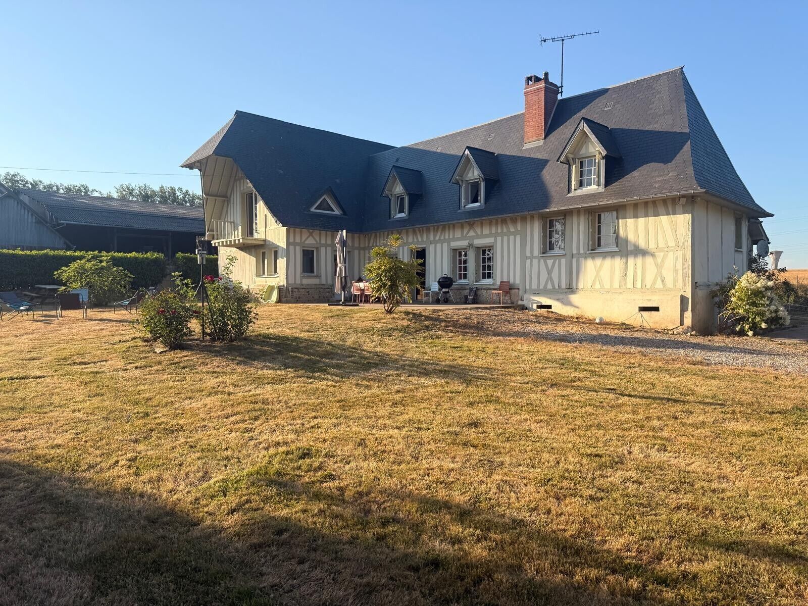 A large house with a dark roof, multiple windows, and a chimney.