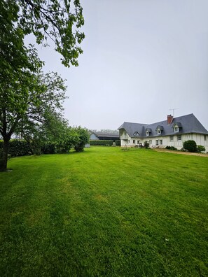 Ein großes Einfamilienhaus mit gepflegtem Rasen und einer Hecke im Vordergrund.
