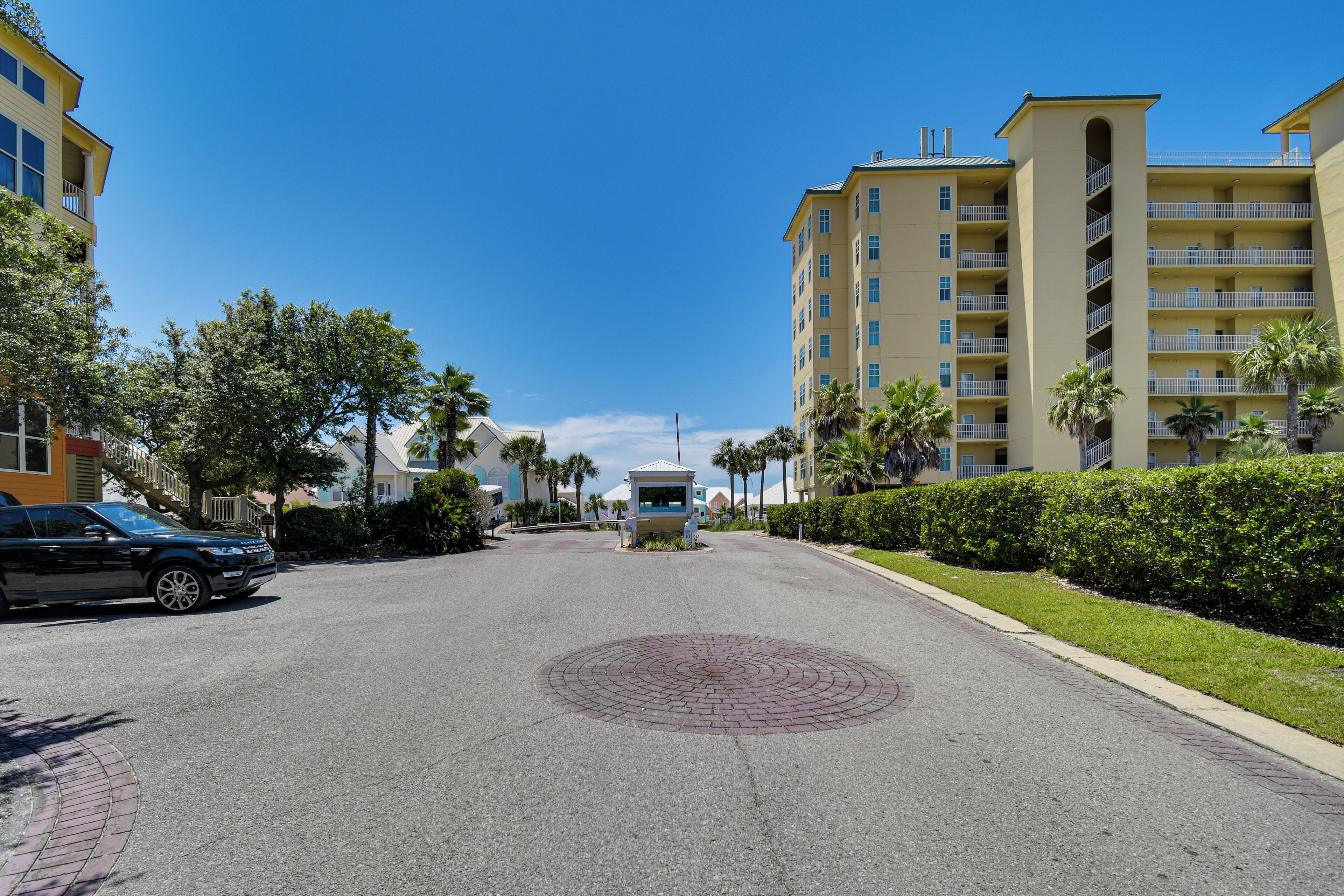 A multi-story hotel with a central courtyard, palm trees, and a clear blue sky.