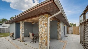 A covered patio with stone pillars, a ceiling fan, and a table with chairs. - Shop, Dine, Explore Dtwn! Punta Gorda Getaway (Punta Gorda)