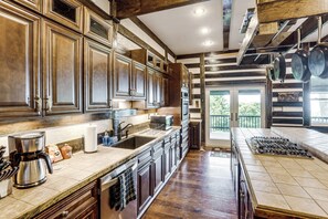 A spacious kitchen with wooden cabinets, a large island, and a view to the outside. - Shenandoah NP Escape w/ Deck: Hike, Soak + Fish (Stanley)