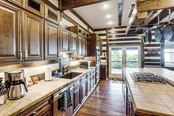 A spacious kitchen with wooden cabinets, a large island, and a view to the outside.
