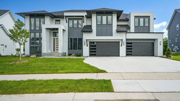 A modern two-story house with a garage, a driveway, and a well-maintained lawn. - Luxe Plymouth Group Getaway w/ Office & Foosball (Plymouth)