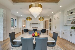 A modern kitchen with white cabinetry, a central island, and pendant lighting. - Luxe Plymouth Group Getaway w/ Office & Foosball (Plymouth)
