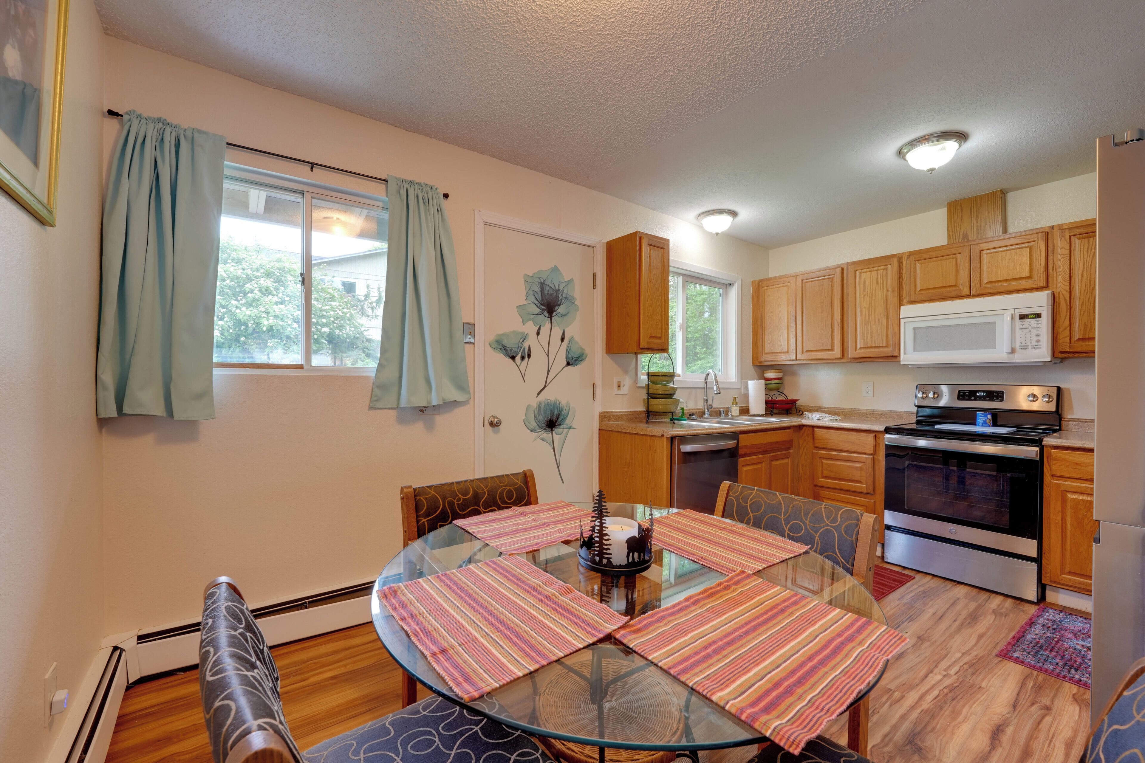 A compact kitchen with wooden cabinets, a microwave, and a stove.
