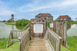 A wooden bridge leading to a private pool area with a sign indicating it is for owners and guests only. - Walk to Matagorda Beach! Condo w/ Pool Access (Matagorda)
