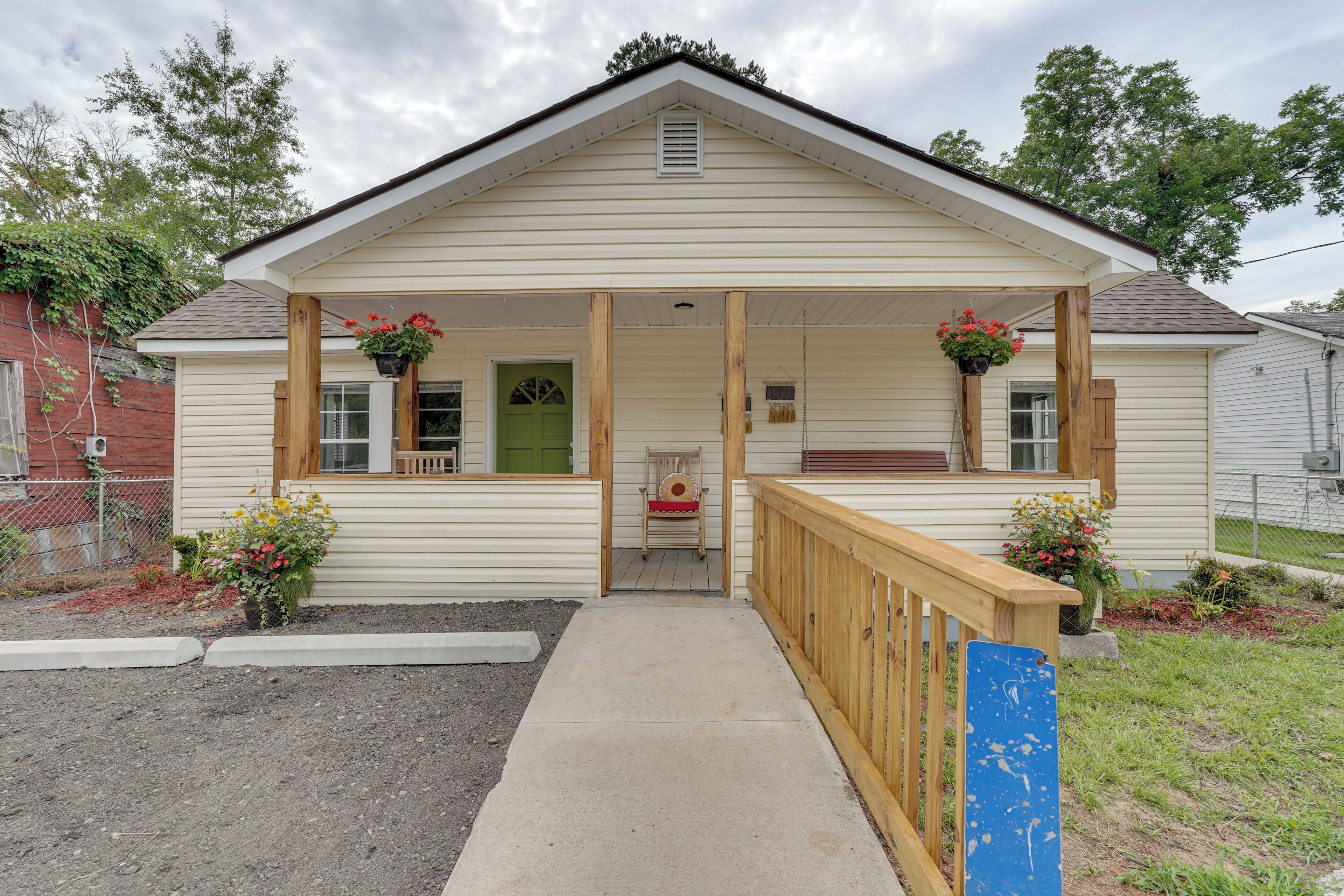 A single-story house with a porch, a front door, and a small seating area.