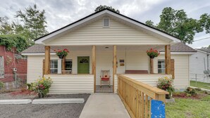 A single-story house with a porch, a front door, and a small seating area.