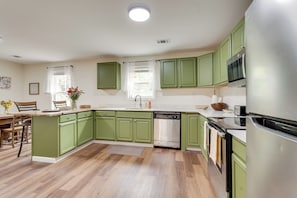 A kitchen with green cabinets, a stainless steel refrigerator, and a dishwasher. - Historic Louisville Steps Away! Work & Play Home (Louisville)