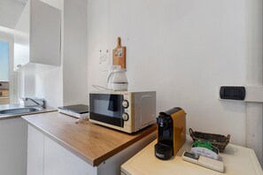 A kitchen with a microwave, a coffee maker, and a scale on the counter. - 'Romaamor Casavacanze' Apartment with Private Terrace, Wi-Fi and Air Conditioning (Rome)