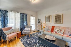 A living room with a sofa, armchair, ottoman, coffee table, and patterned rug. - Pets Welcome! Woodland Family Haven w/ Large Yard (Woodland)