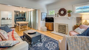 A living room with a fireplace, a dining area, and a kitchen.