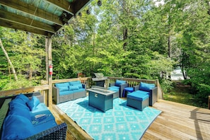 A wooden deck with outdoor furniture, a grill, and a fire pit. - Dock & Gym! Lakefront Family Retreat in Lincoln (Lincoln)