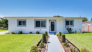 A single-story house with a front door, two windows, and a small front yard with a pathway. - Close to Hard Rock Stadium! Group Getaway w/ Yard (Miami Gardens)