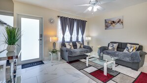 A modern living room with a sofa, coffee table, and a ceiling fan. - Close to Hard Rock Stadium! Group Getaway w/ Yard (Miami Gardens)