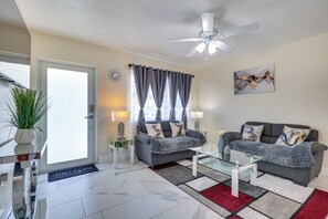 A modern living room with a sofa, coffee table, and a ceiling fan.