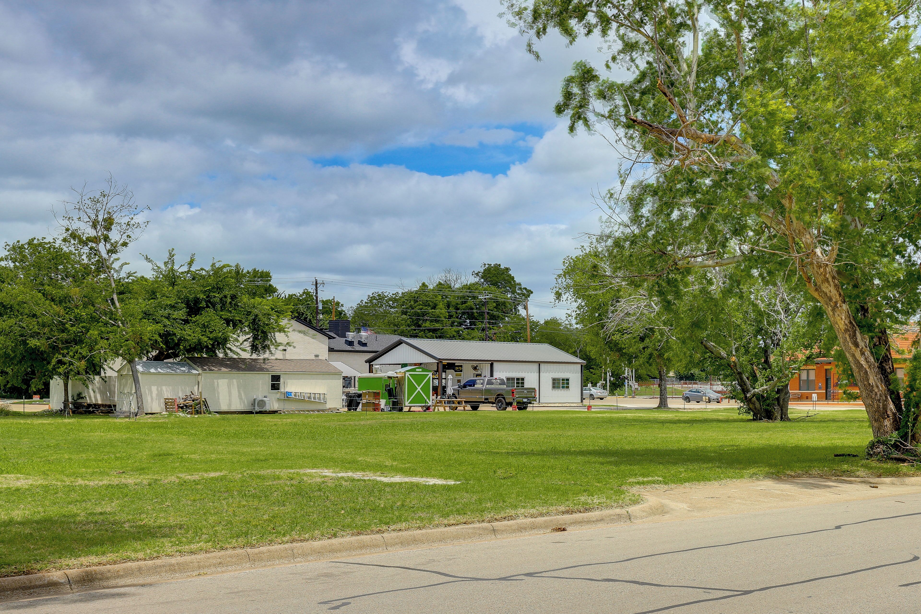 A residential area with a house, a small shed, and a truck parked on the street.