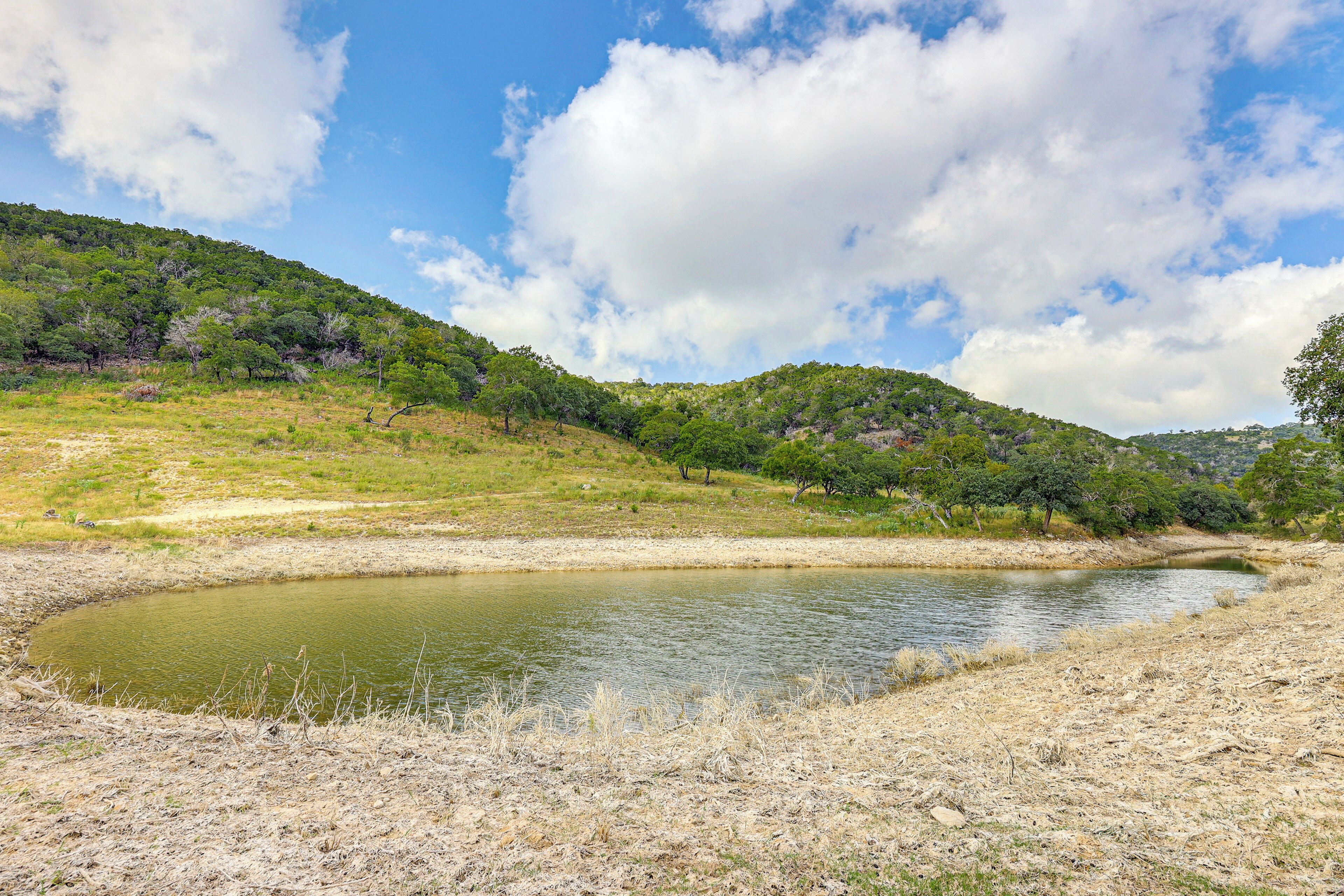 A natural landscape with a river, grassy areas, and hills.