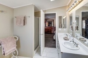 Une salle de bain avec un lavabo blanc, un grand miroir et un porte-serviettes.