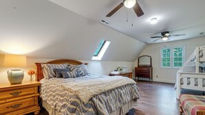A bedroom with a bed, a dresser, a vanity, a window, and a ceiling fan. - 10-acre Retreat w/ Hiking! Gateway to Holden Beach (Shallotte)