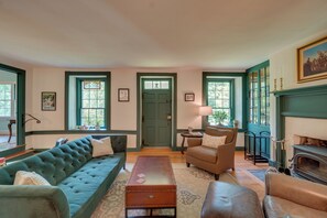 A living room with a green sofa, a brown leather armchair, a wooden coffee table, and a fireplace.