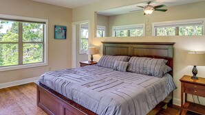 A bedroom with a large bed, a ceiling fan, and multiple windows. - Asheville Mountain Hideaway, 6 Mi to Dtwn (Asheville)