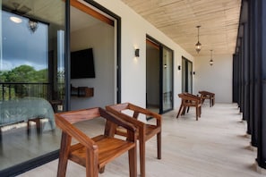 A modern interior with wooden furniture, a large glass window, and a ceiling with exposed beams. - Resort Living in Tulum! Walkable Downtown Condo (Tulum)