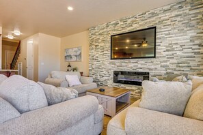 Ein Wohnzimmer mit Kamin, Sofas und einer Steinwand.