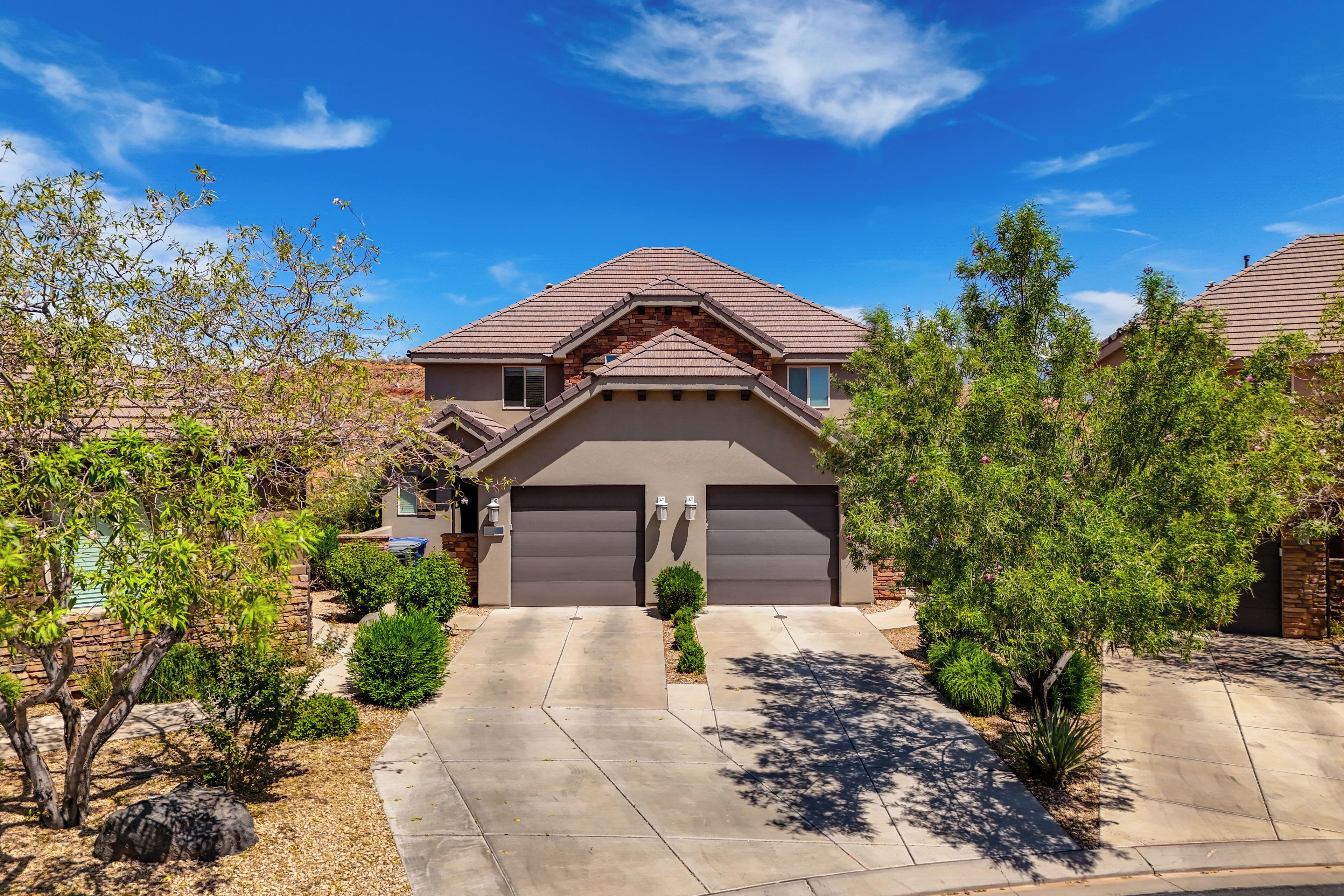 A residential house with a garage, driveway, and landscaping.