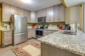 A modern kitchen with stainless steel appliances, granite countertops, and wooden cabinets. - Linger Longer Mtn-view San Isabel Forest Haven (Beulah)
