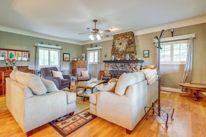 A living room with two sofas, a coffee table, a fireplace, and a ceiling fan. - Linger Longer Mtn-view San Isabel Forest Haven (Beulah)