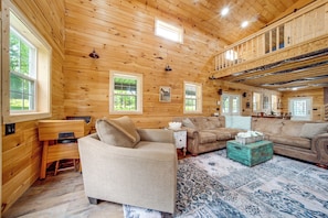A log cabin interior with a sofa, a coffee table, and a piano. - 3 Mi to Shenango Lake! Dusk-to-dawn Barndominium (Hermitage)