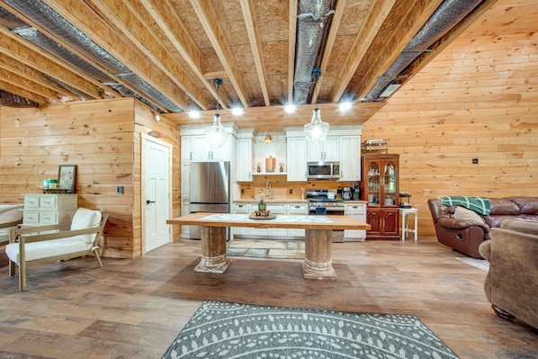 A wooden interior with a kitchen, dining area, and seating.