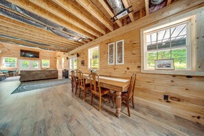 A wooden interior with a dining table and chairs, a sofa, and a large window. - 3 Mi to Shenango Lake! Dusk-to-dawn Barndominium (Hermitage)