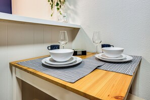 A small wooden table with two white bowls and two wine glasses, each with a blue mug. - 1 Mi to UT & Med Centers! Updated Austin Studio (Austin)