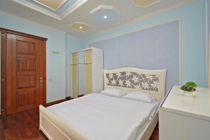 A bedroom with a bed, a wardrobe, and a desk with a plant. - Apartment by Luxe Group AB917 (Yerevan)