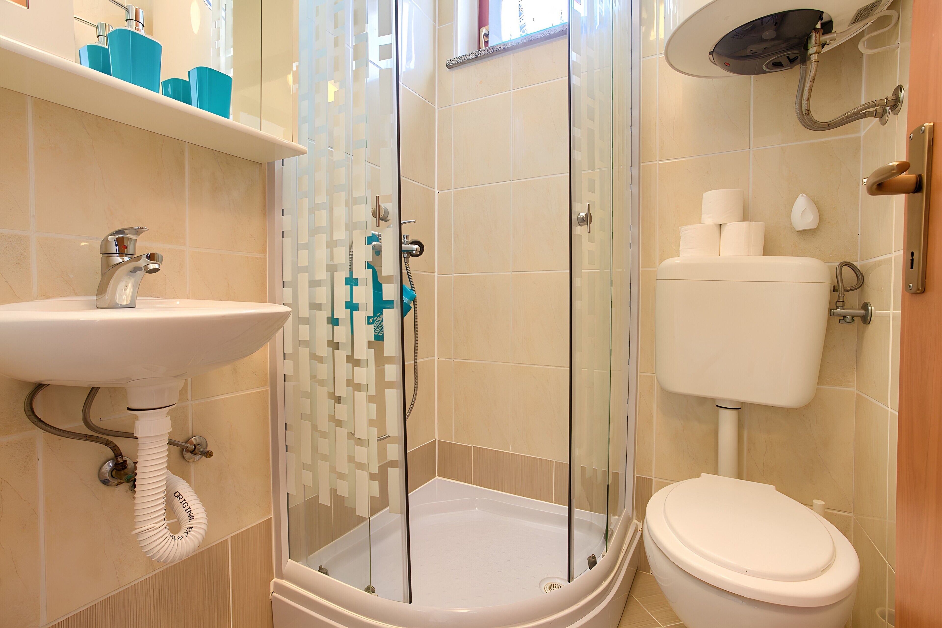 Ein Badezimmer mit Duschkabine, Waschbecken und Toilette.