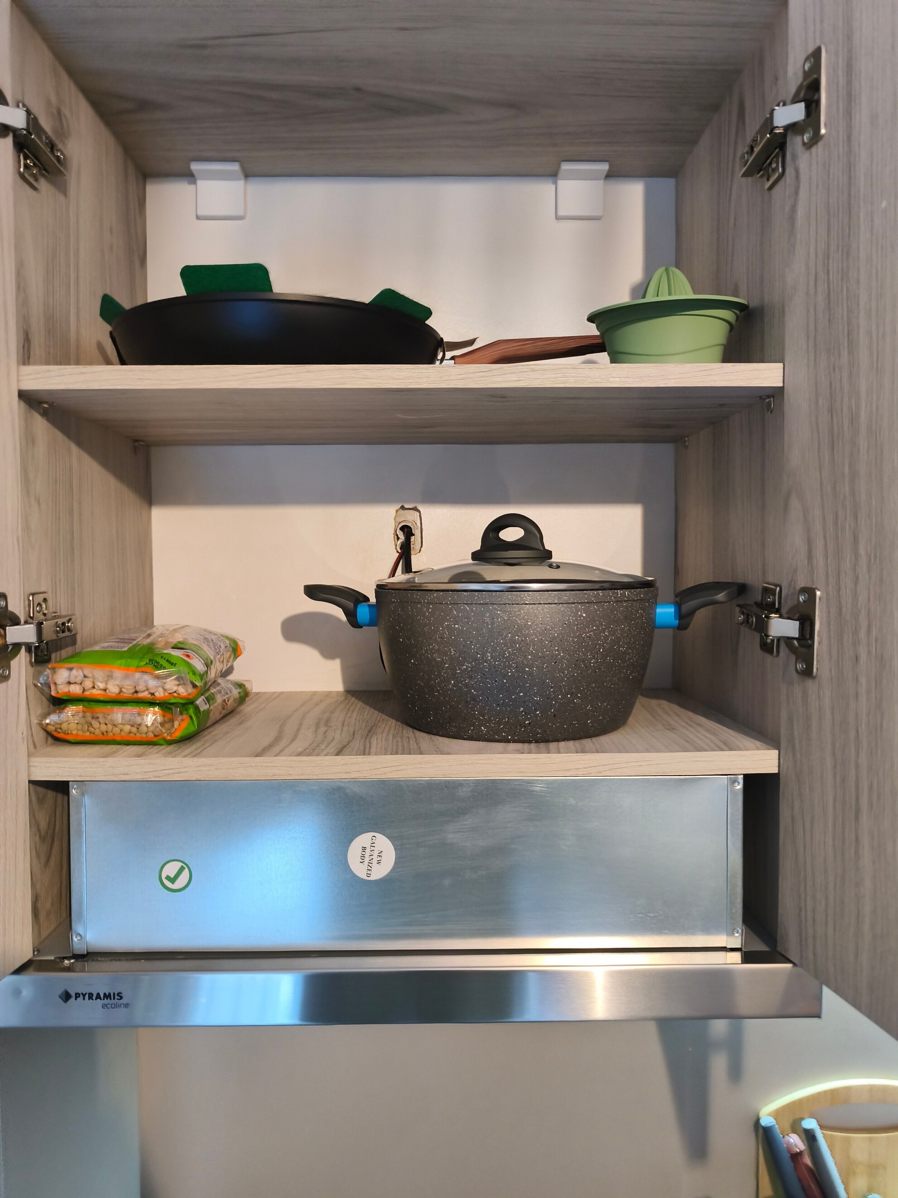 A kitchen with a pot on the countertop, a bag of rice, and a stainless steel appliance.