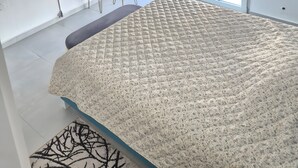 A bedroom with a bed, a desk, a chair, a hanging plant, and a window with blinds. - Mokshouse – Bright, Comfortable Apartment near City Center and Beach (Kavala)