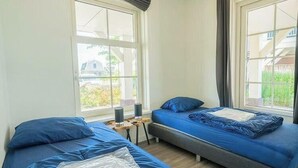 A room with two beds, a small table, and a window. - Holiday Home in Uitdam With Terrace (Uitdam)