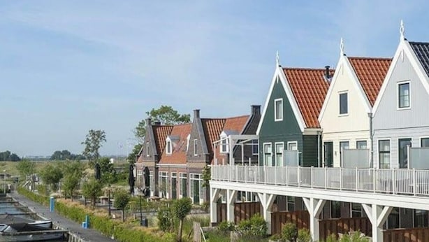 A row of houses with gabled roofs and a wooden walkway over a canal. - Holiday Home in Uitdam With Terrace (Uitdam)