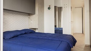 Een slaapkamer met een bed, een kledingkast en een spiegel.
